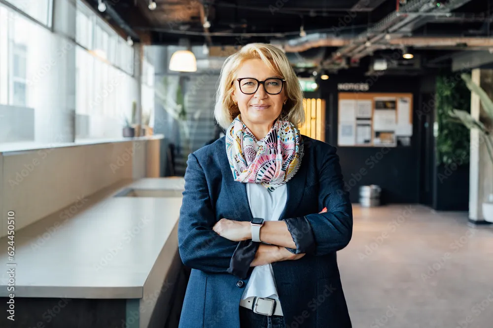 Portrait of smiling 50's stylish, confident mature businesswoman, middle aged company ceo director, experienced senior female professional, business coach team leader in modern office. Female leader